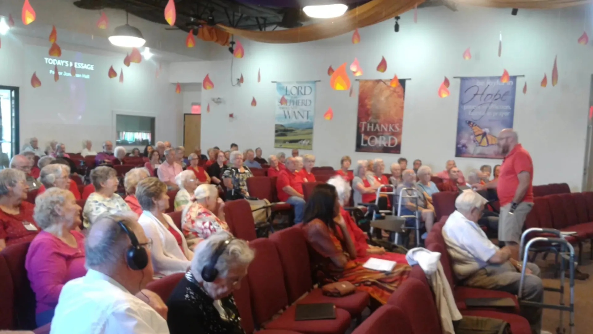 18 people sitting on chair in front of table while holding pens during daytime